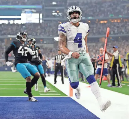  ?? TIM HEITMAN/USA TODAY SPORTS ?? Cowboys quarterbac­k Dak Prescott rushed for a touchdown and 82 yards and threw for two TDs and 183 yards Sunday in the rout of the Jaguars.