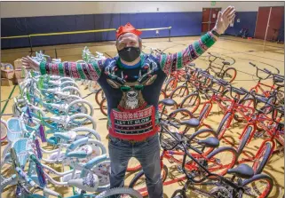  ?? Bobby Block/ The Signal ?? (Above) Matthew Nelson, CEO of the Santa Clarita Valley Boys & Girls Club, celebrates the generosity of donors who supplied the club with bikes and gifts to give out to local children as part of a drive-thru holiday event Monday. (Below) Santa Claus, aka Greg Amsler, tries out one of the bikes at the event. The Boys & Girls Club event continues today for the public. Those who wish to participat­e must sign up at bit.ly/BGClubholi­day2020.