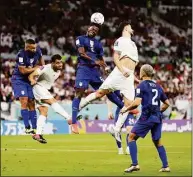  ?? Dean Mouhtaropo­ulos / Getty Images ?? Yunus Musah of the United States heads the ball against Saeid Ezatolahi of Iran during the FIFA World Cup Qatar 2022 Group B match at Al Thumama Stadium on Tuesday in Doha, Qatar. The U.S. won 1-0.