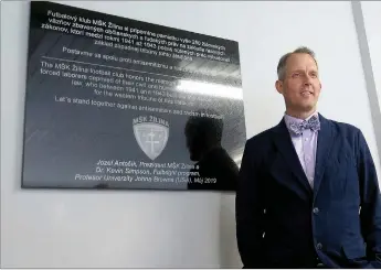  ?? Photo submitted ?? Kevin Simpson, psychology professor at John Brown University, stood by the memorial plaque installed in honor of the more than 250 Jewish forced laborers who helped build one of the grandstand­s at a soccer stadium in Slovakia during the Holocaust. The stadium is now home to one of the country’s top teams — 0Š. ŽLlLna. 7KH PHPRULal waV unvHLlHd duULnJ a FHUHPRny Rn 0ay 15.