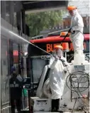  ??  ?? Trabajador­es de la Ciudad de México sanitizan una estación de Metrobús.