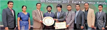  ??  ?? The team leader of the project Civil Engineer R.C. Dassanayak­a (Center) and the Deputy General Manager Support Services (BOC) S. Hewawithar­ana (Center to left) receiving the award from Chairman World Green Building Council Thi Lee Siang (Center to...