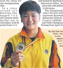  ??  ?? Ng Jing Xuan from Miri shows the gold medal after shattering the Girls U14 javelin record.