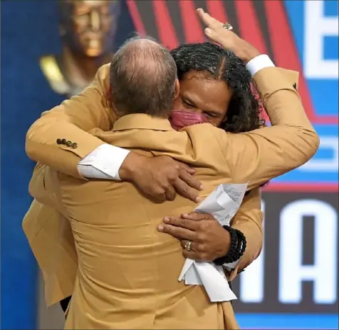  ?? Matt Freed/Post-Gazette ?? Troy Polamalu hugs Bill Cowher after giving his enshrineme­nt speech Saturday night at Tom Benson Hall of Fame Stadium in Canton, Ohio. Because of a positive COVID-19 test last week, there was a question whether Polamalu would be able to attend.