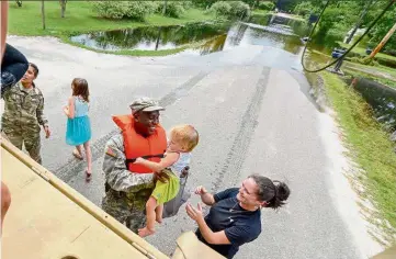  ??  ?? Lending a hand: US Army Pfc Marlen Squire of the South Carolina National Guard helping to evacuate residents from flood-hit Dongola, South Carolina.