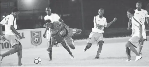  ??  ?? Man Down: Gideon Payne (centre) of Den Amstel is fouled while being surrounded by five Victoria Kings’ players at the National Track and Field Centre, Leonora in the GFF’s Stag Beer Super 16 Championsh­ip.