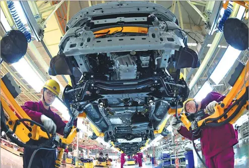  ?? LIU LIQIN / FOR CHINA DAILY ?? Workers assemble new cars at a production line at JAC Motor’s plant in Bozhou, Anhui province.