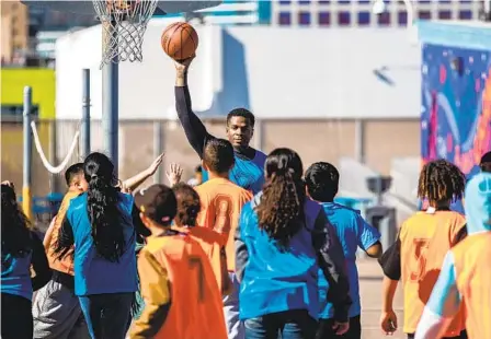  ?? MEG MCLAUGHLIN U-T ?? Harlem Globetrott­er Flip White plays basketball with kids in Arden Pala’s Sports4Kid­s program at Perkins K-8 School on Tuesday.