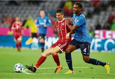  ??  ?? Out of my way: Bayern Munich’s Robert Lewandowsk­i (left) vying for the ball with Bayer Leverkusen’s Jonathan Tah in the Bundesliga match at the Allianz Arena on Friday. Bayern won 3-1. — Reuters