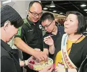  ??  ?? 現場亦有進行試吃活動，工作人員向民眾介紹台­灣彰化的蔬果產品。