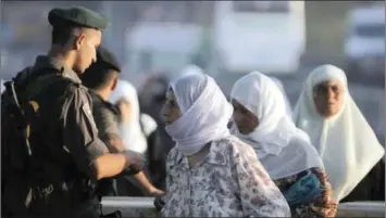  ?? PICTURE: REUTERS ?? An Israeli border policeman checks the identity of Palestinia­n women as they cross into Jerusalem at a checkpoint outside the West Bank city of Ramallah.