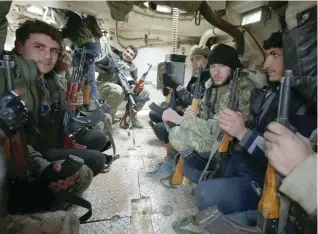  ?? — Reuters ?? Rebel fighters ride a military vehicle, as they advance towards the northern Syrian town of Al Bab.