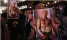  ??  ?? Protesters hold posters of US president Donald Trump during a Thanksgivi­ng Day rally. Photograph: Chris McGrath/Getty Images