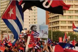  ?? REUTERS ?? People carry a poster with photograph­s of Fidel Castro, Miguel Diaz-canel and Raul Castro during a rally in Havana, Cuba, on July 17, 2021.