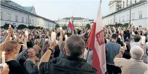  ?? ALIK KEPLICZ/THE ASSOCIATED PRESS ?? Protesters raise candles during a protest in front of the presidenti­al palace in Warsaw, Poland, on Tuesday as they urge Polish President Andrzej Duda to reject a bill changing the judiciary system.