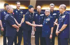  ?? BERNAMAPIX ?? Fuzi (second from right) being greeted by senior police officers at the function yesterday.