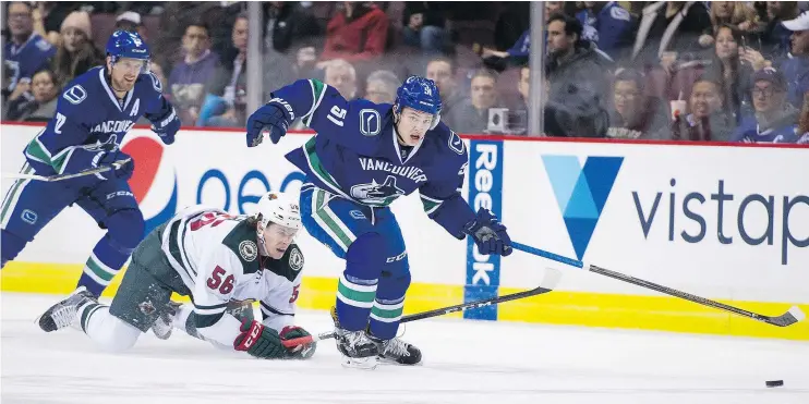  ?? GERRY KAHRMANN /PNG ?? Vancouver defenceman Troy Stecher, right, steals the puck from the Minnesota Wild’s Erik Haula Tuesday during the Canucks’ 5-4 win at Rogers Arena.