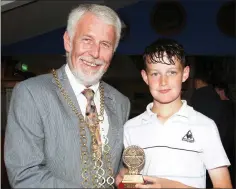  ??  ?? Cillian Byrne from Cleariesto­wn receives his trophyfrom Cllr. Jim Moore for winning the Under-16 competitio­n.