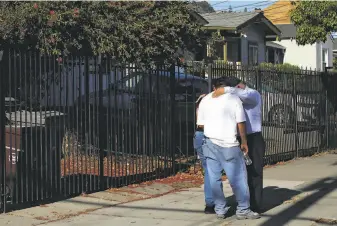  ?? Yalonda M. James / The Chronicle ?? Pastor Jose Rojas ( right) of the Pentecosta­ls of Oakland prays with a couple who lost a loved one in a shooting on 84th Avenue on Thursday. “Sometimes I wish we could do more,” he said.