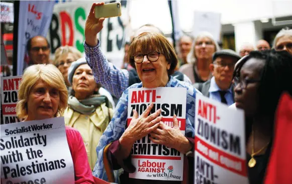  ?? (Henry Nicholls/Reuters) ?? SUPPORTERS OF Britain’s Labour Party take part in protests outside a meeting of its National Executive, which was discussing the party’s definition of antisemiti­sm, in London in 2018.