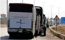  ?? — Reuters/Omar Sanadiki ?? END GAME: A driver stands next to a bus as he waits to cross into the town of Douma, eastern Ghouta, to evacuate rebels and their families, at Wafideen camp in Damascus, Syria April 1, 2018.