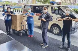  ??  ?? UP-PGH medical workers receive lunch packs from COD Manila.