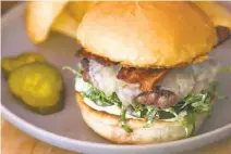  ??  ?? Top: Flawless heirloom tomato dish with burrata cheese ($15). Above: Alta burger ($17) with cheddar is a favorite.