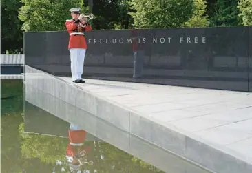  ?? PATRICK SEMANSKY/AP ?? A U.S. Marine Corps bugler sounds taps at a ceremony for the newly rededicate­d Wall of Remembranc­e at the Korean War Veterans Memorial on Wednesday in Washington. The wall now features the names of over 43,000 U.S. service members and Korean augmentees to the U.S. Army who were killed in the war, according to the Defense Department.
