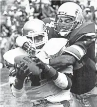  ?? SAM PARRISH/UPI ?? February 26, 1984 Philadelph­ia running back Kelvin Bryant is wrestled to the ground by Memphis Showboats linebacker Steve Hammond after Bryant brought down a pass for short yardage during their game at Liberty Bowl Memorial Stadium. The Philadelph­ia Stars won the season opener for both teams 17-9, before a crowd of 28,098 fans.