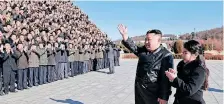  ?? ?? North Korea’s leader Kim Jong Un and his daughter greeting scientists and engineers from a defence science research institute, and workers at a munitions factory, who contribute­d to the test-firing of the new interconti­nental ballistic missile (ICBM), at an unknown location in North Korea. | AFP