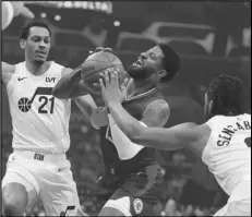  ?? Associated Press ?? Clippers forward Paul George drives to the basket against Utah Jazz forwards Darius Bazley (21) and Brice Sensabaugh during the first half on Friday in Los Angeles.