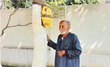  ?? ?? Bholanath Alok next to the tree in the garden of his house in Sipahi Tola of Purnia district, some 350 km east of Patna, to which he has secured the urn with his wife’s ashes.