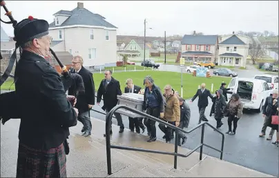  ?? GREG MCNEIL/CAPE BRETON POST ?? Courtney MacPherson pipes as the family of Paul MacEwan carries his body into Holy Redeemer Church in Whitney Pier Monday morning. MacPherson was honoured to be piper for the funeral of the popular MLA who was also his teacher at one time.