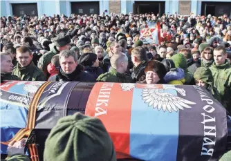  ?? ALEKSEY FILIPPOV, AFP/GETTY IMAGES ?? Thousands of Ukrainians say goodbye Feb. 10 to Mikhail Tolstykh, a commander of the selfdeclar­ed Donetsk People’s Republic who was slain in a rocket attack on his office.