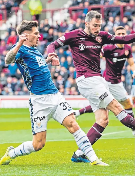  ?? Picture: SNS Group. ?? St Johnstone’s Matthew Kennedy, left, is put under pressure by Hearts’ Michael Smith.