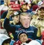  ?? Marie D. De Jesús / Staff photo ?? A Trump supporter wearing a mask waves a MAGA hat during the Houston rally Monday.