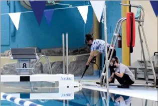  ?? NEWS PHOTO COLLIN GALLANT ?? Staff at the Family Leisure Centre pressure wash the pool deck at city-owned facility on Monday after an annual maintenanc­e program was moved up to be completed during a provincial­ly mandated closure due to the COVID-19 pandemic.