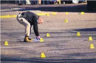  ?? ADOLPHE PIERRE-LOUIS/JOURNAL ?? An Albuquerqu­e Police Department officer collects evidence at the scene of a shooting at the Rosewood Mobile Home Park Sunday morning. A teenage boy was shot in the back while he was sleeping.