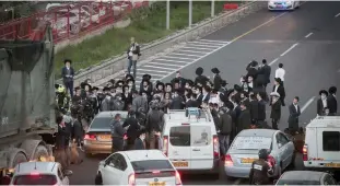  ?? (Noam Revkin Fenton/Flash90) ?? BNEI BRAK residents block traffic during a protest against drafting to the army last year.