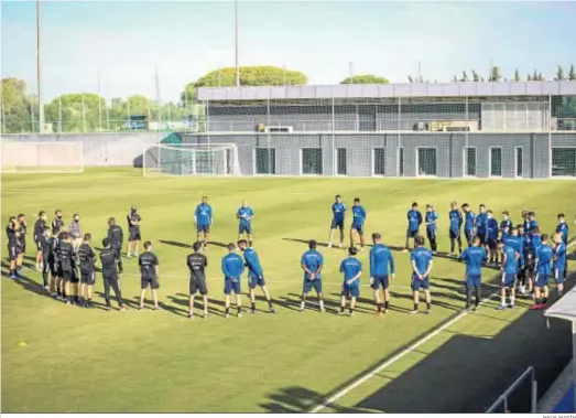  ?? JESÚS MARÍN ?? Cuerpo técnico y jugadores forman un corro durante un entrenamie­nto en El Rosal.