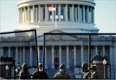  ?? EVAN VUCCI / AP ?? With the U.S. Capitol in the background, authoritie­s stand behind newly placed fencing around the Capitol grounds Thursday, the day after protesters loyal to President Trump stormed the U.S. Congress. The breachwill undoubtedl­y lead to changes in security at the Capitol, said a professor of history and lawat Cedarville University.