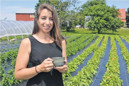  ?? DANIEL BROWN/THE GUARDIAN ?? Janell MacDonald enjoys a cup of tea in her garden at the New Argyle Farmery. Behind her are many plants, like calendula, anise hyssop, oregano, thyme and sage.