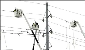  ?? DANIEL MEARS — DETROIT NEWS VIA AP ?? ITC Transmissi­on, a subsidiary of DTE Energy, basket trucks work on power lines along 8 Mile near Wanda in Ferndale on Saturday.