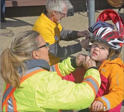  ?? SCOTT ANDERSON/SOUTHWEST BOOSTER ?? June Martens has her helmet safety inspected at the Bike Safety Event hosted at Highland Park this past Wednesday.