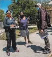  ?? Nick Otto / Special to The Chronicle ?? Dr. Kim Rhoads (center) inspects Herz Playground in Visitacion Valley, where virus testing will be available.