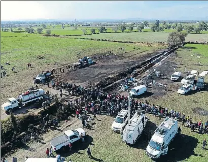  ?? CLAUDIO CRUZ / AP ?? Forenses en el oleoducto de Tlahuelilp­an, que el 18 de enero estalló al ser pinchado: hubo 130 muertos