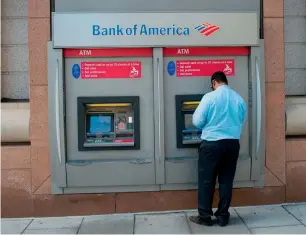  ?? — AFP ?? A man using an ATM at a Bank of America branch in Washington, DC. Wall Street stocks advanced early on Monday ahead of a heavy week of corporate earnings including major companies such as Bank of America, Netflix, General Electric and others.