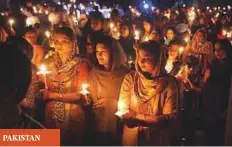  ??  ?? PAKISTAN ■ Pakistani Christian devotees holding candles while attending an Easter vigil mass at the Sacred Heart Church in Lahore yesterday.