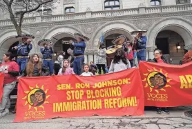  ?? MIKE DE SISTI / MILWAUKEE JOURNAL SENTINEL ?? A mariachi band plays as banners are held outside U.S. Sen. Ron Johnson’s office at the Federal Courthouse during the march for immigratio­n reform in Milwaukee on Sunday.