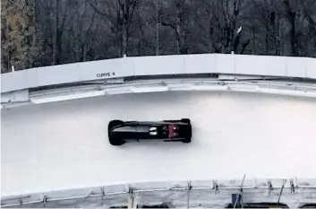  ?? PETER MORGAN/ THE CANADIAN PRESS ?? A bobsled driven by Justin Kripps, of Canada, rounds a curve during training before a World Cup event in Lake Placid, N. Y., on Nov. 8.